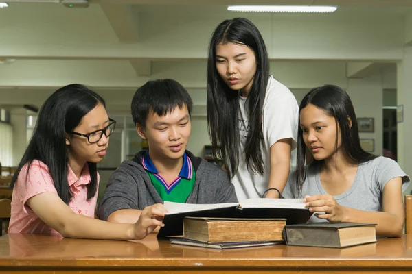 kitaplığındaki kitap okuyarak ciddi, genç bir öğrenci portresi