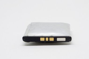 Eski beyaz bir arka plan üzerinde cep telefonu için pil kabartmak