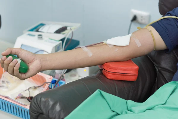 Blood donor at donation with a bouncy ball holding in hand. — Stock Photo, Image