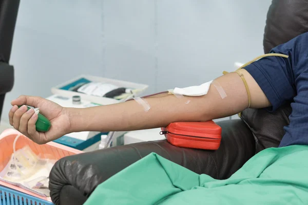 Blood donor at donation with a bouncy ball holding in hand. — Stock Photo, Image