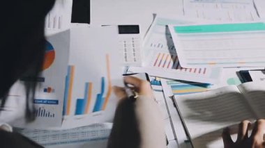 Modern ofiste belgelerle çalışan genç bir iş kadını.