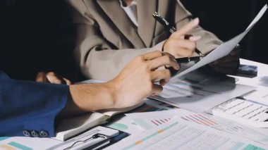 Modern ofis masasında çalışan iş kadınlarının ellerinin kapatılması mali belgeler ve belgeler masanın üzerinde, iş adamı dizüstü bilgisayarla çalışıyor