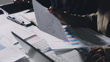 Genç iş kadını ofiste masada oturuyor ve dizüstü bilgisayarla çalışıyor..