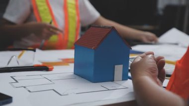 Mimar, evin planı üzerinde çalışıyor.