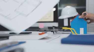 Evdeki planlarla çalışan genç bir adam..