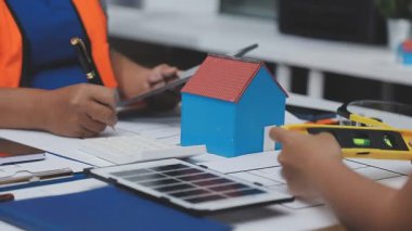 Genç bayan mühendis ofiste ev modeliyle çalışıyor.