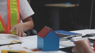 Asyalı kadın mühendis ev planı üzerinde çalışıyor. Ev planı, inşaat, ev, mühendislik, emlak konsepti..