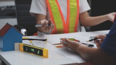 Mühendis ve kadın ofis planı, mühendislik ve inşaat konsepti üzerinde çalışıyorlar..