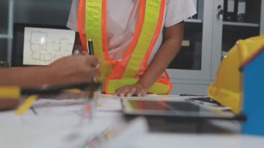 İnşaat odasında güvenlik kaskı olan güvenlik şapkası mühendisi mühendisi. İnşaat mühendisi arka planda inşaat araçlarıyla çalışıyor..
