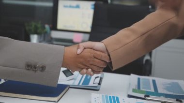 Modern bir ofiste iş adamları el sıkışıyor, tokalaşıyor, tokalaşıyor.