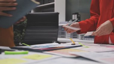 Kadın mühendis ofisteki planlara çizim yapıyor.