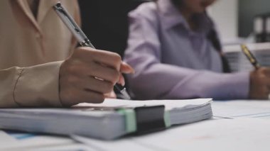 Genç iş adamları ofiste kağıda yazı yazıyorlar..