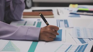 İş kadını eli kalem ve hesap makinesini masanın üzerinde tutuyor..