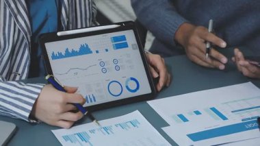 iş ekibi tablet üzerinde mali verileri tartışıyor