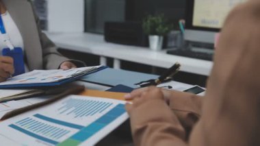 Genç Asyalı iş kadını laptoptaki verileri analiz ediyor.