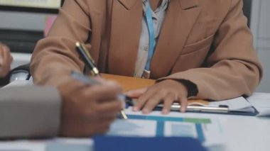 Finans belgesi ve mali muhasebe kavramının rakamlarını hesaplamak için hesap makinesi kullanan bir iş kadını