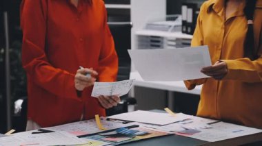 Uxui tasarımcılarından oluşan bir ekip bilgisayar ekranını işaret ederek ofiste yeni mobil uygulama tasarımını tartışıyor.