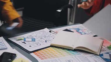 Uxui tasarımcılarından oluşan bir ekip bilgisayar ekranını işaret ederek ofiste yeni mobil uygulama tasarımını tartışıyor.