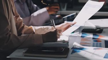 Finans belgesi ve mali muhasebe kavramının rakamlarını hesaplamak için hesap makinesi kullanan bir iş kadını