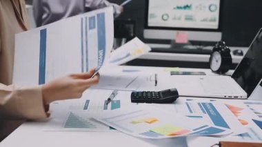 Finans belgesi ve mali muhasebe kavramının rakamlarını hesaplamak için hesap makinesi kullanan bir iş kadını