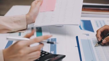 Finans belgesi ve mali muhasebe kavramının rakamlarını hesaplamak için hesap makinesi kullanan bir iş kadını