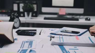 Finans belgesi ve mali muhasebe kavramının rakamlarını hesaplamak için hesap makinesi kullanan bir iş kadını