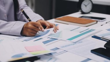 Finans belgesi ve mali muhasebe kavramının rakamlarını hesaplamak için hesap makinesi kullanan bir iş kadını