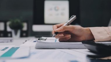 Finans belgesi ve mali muhasebe kavramının rakamlarını hesaplamak için hesap makinesi kullanan bir iş kadını