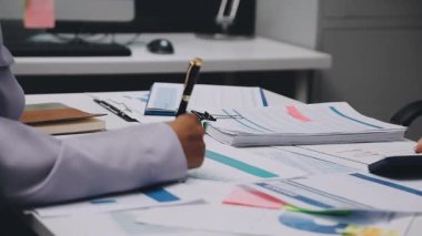 Finans belgesi ve mali muhasebe kavramının rakamlarını hesaplamak için hesap makinesi kullanan bir iş kadını