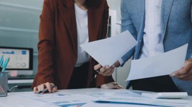 Finans belgesi ve mali muhasebe kavramının rakamlarını hesaplamak için hesap makinesi kullanan bir iş kadını