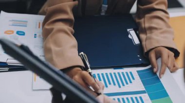 Finans belgesi ve mali muhasebe kavramının rakamlarını hesaplamak için hesap makinesi kullanan bir iş kadını