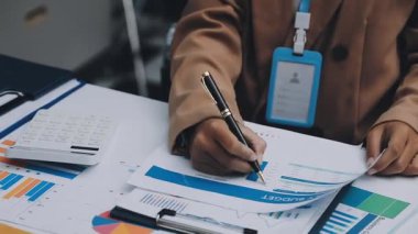 Finans belgesi ve mali muhasebe kavramının rakamlarını hesaplamak için hesap makinesi kullanan bir iş kadını