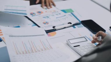 Finans belgesi ve mali muhasebe kavramının rakamlarını hesaplamak için hesap makinesi kullanan bir iş kadını