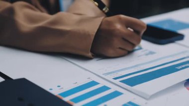 Finans belgesi ve mali muhasebe kavramının rakamlarını hesaplamak için hesap makinesi kullanan bir iş kadını