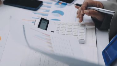 Finans belgesi ve mali muhasebe kavramının rakamlarını hesaplamak için hesap makinesi kullanan bir iş kadını