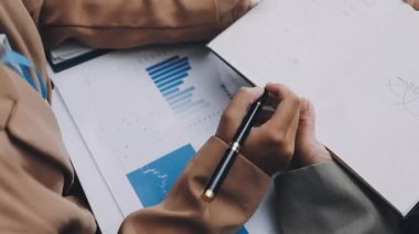 Finans belgesi ve mali muhasebe kavramının rakamlarını hesaplamak için hesap makinesi kullanan bir iş kadını