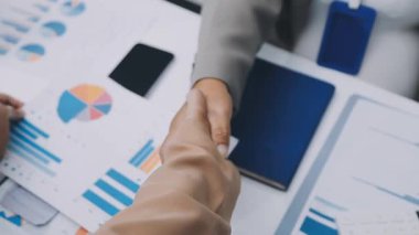 Genç iş adamları ofiste el sıkışıyor. Başarılı toplantı sona eriyor. Üç kişi