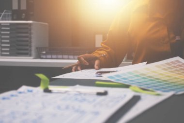 Uxui tasarımcılarından oluşan bir ekip bilgisayar ekranını işaret ederek ofiste yeni mobil uygulama tasarımını tartışıyor.