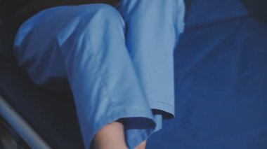 Asyalı fizyoterapist yaşlı bir kadının bacaklarını iyileştirmek için fizik tedavi uyguluyor..