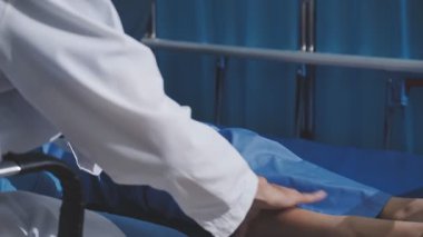 Asyalı fizyoterapist yaşlı bir kadının bacaklarını iyileştirmek için fizik tedavi uyguluyor..