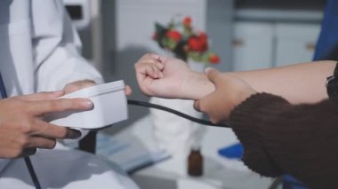 Teste gir, elinden geleni yap. Evde tansiyon ölçer ile yaşlı bir kadını muayene eden bir doktorun fotoğrafı..