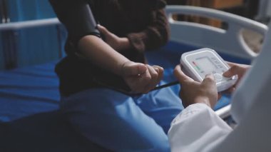 Teste gir, elinden geleni yap. Evde tansiyon ölçer ile yaşlı bir kadını muayene eden bir doktorun fotoğrafı..