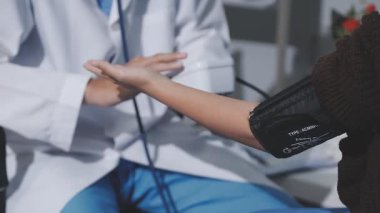 Teste gir, elinden geleni yap. Evde tansiyon ölçer ile yaşlı bir kadını muayene eden bir doktorun fotoğrafı..