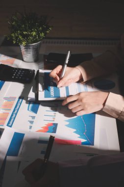 Above table with finance papers, graphs and big data during teamwork meeting with accounting or marketing team discussing budget, strategy or growth development. Closeup of SEO team doing research
