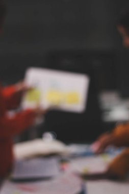 Uxui tasarımcılarından oluşan bir ekip bilgisayar ekranını işaret ederek ofiste yeni mobil uygulama tasarımını tartışıyor.