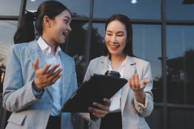 İş adamları modern ofisin önünde yürür ve birbirleriyle konuşurlar.