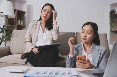 İki iş kadını ofiste dizüstü bilgisayarla çalışırken stresli hissediyorlar