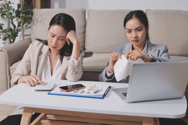 İki iş kadını ofiste dizüstü bilgisayarla çalışırken stresli hissediyorlar