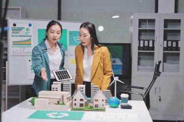 İki iş adamı ekibi güneş pili ve rüzgar türbini jeneratörü ile sürdürülebilir ve yenilenebilir temiz enerji ürünü, CO2 emisyonları küresel ısınma projesini planlıyor ve tartışıyor.