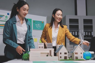 İki iş adamı ekibi güneş pili ve rüzgar türbini jeneratörü ile sürdürülebilir ve yenilenebilir temiz enerji ürünü, CO2 emisyonları küresel ısınma projesini planlıyor ve tartışıyor.